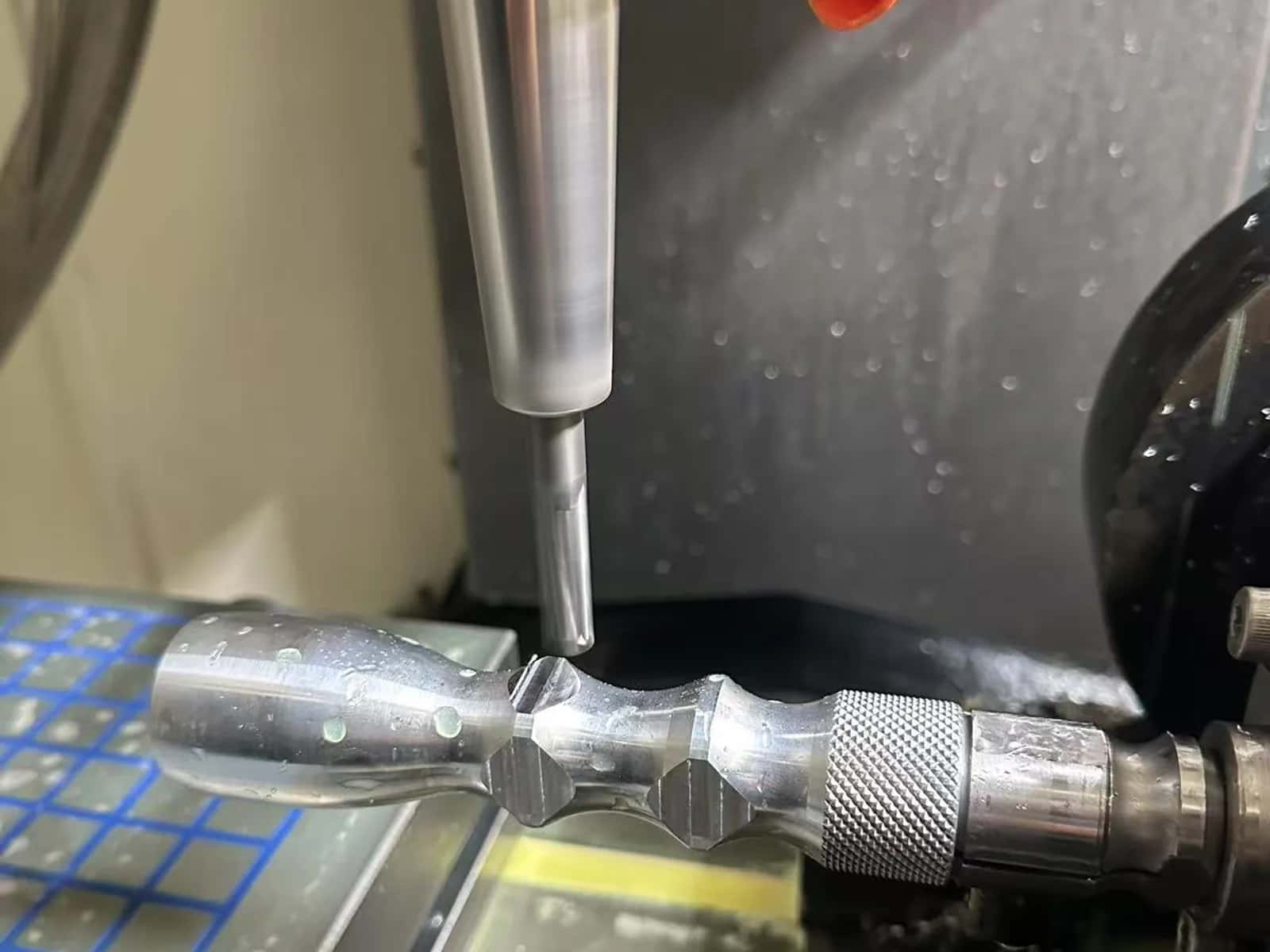 Live-tool milling of a knurled aluminum shaft inside a CNC cell with coolant nozzles