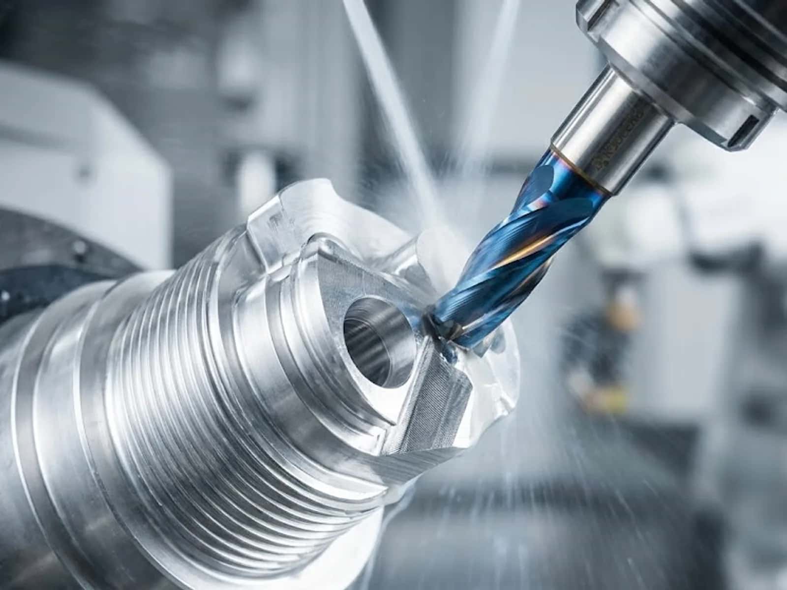 Coated end mill cutting a cylindrical metal workpiece with dual coolant jets