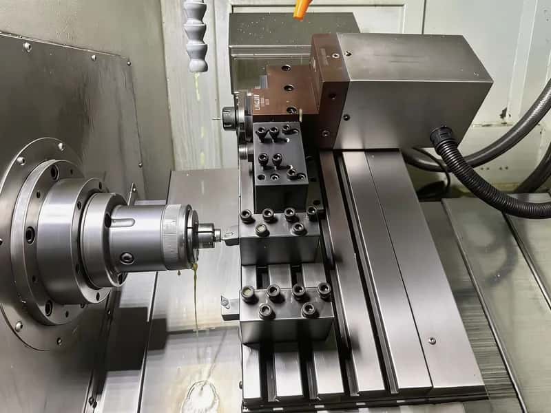 Swiss-style gang tooling turning a small diameter workpiece with coolant